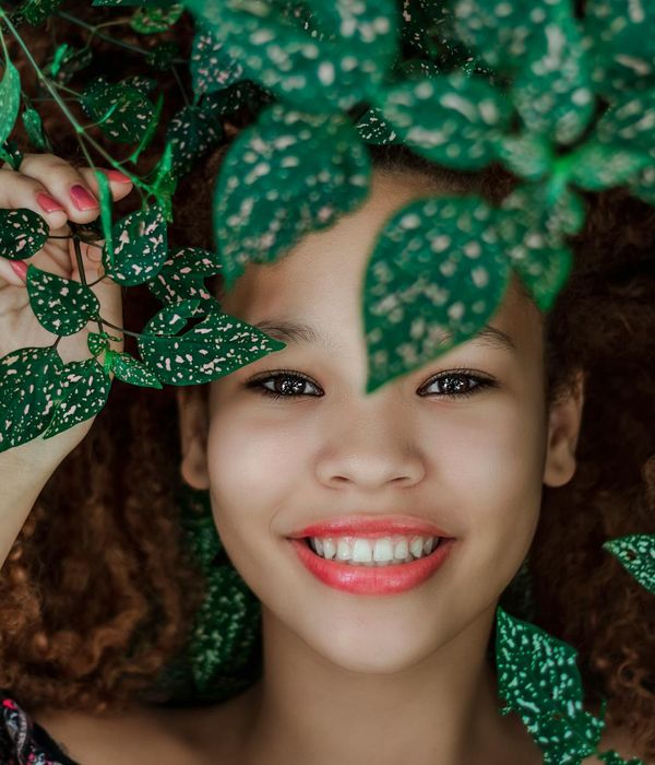 Serene person with eyes closed in a calm environment.